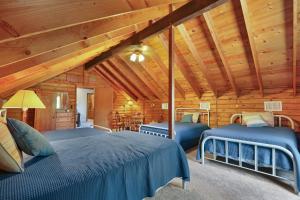 um quarto com 2 camas num chalé de madeira em Cousins River Retreat em Martindale