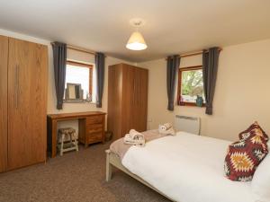 a bedroom with a bed and a desk in it at Roan Cottage in Lydiard Millicent