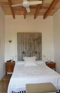 1 dormitorio con 1 cama blanca grande y 2 mesitas de noche en Sa Riba, Country house in Mallorca, en Son Carrió