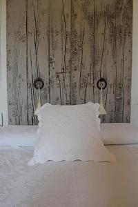 Una cama con una almohada blanca y dos luces. en Sa Riba, Country house in Mallorca, en Son Carrió