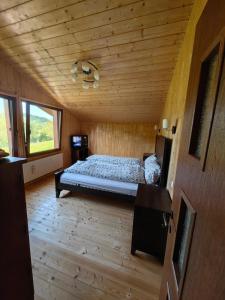 um quarto com uma cama num quarto de madeira em Raw Nature Chalet em Crivina
