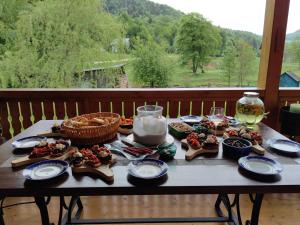 - une table avec des assiettes de nourriture et un verre de vin dans l'établissement Raw Nature Chalet, à Crivina