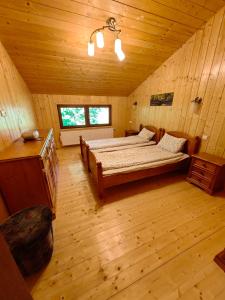 - une chambre avec un lit dans une pièce en bois dans l'établissement Raw Nature Chalet, à Crivina