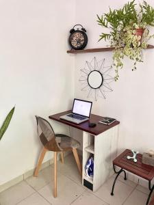 a desk with a laptop computer on top of it at La Pierre des Ducs in Matoury