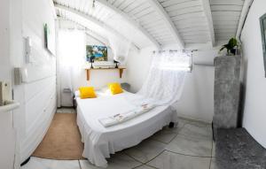 - une chambre avec un lit et des oreillers jaunes dans l'établissement La villa du soleil 971, à Anse-Bertrand
