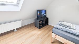 Cette petite chambre dispose d'une télévision et d'un lit. dans l'établissement ALFA Stuttgart 3BR 5 Beds Netflix INET EBK Wasen, à Stuttgart