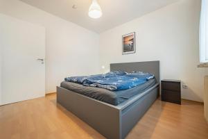 a bedroom with a bed with a blue blanket on it at Ferienwohnung Große in Osterode