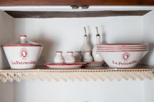 a shelf with bowls and vases on it at La Petronilla Appartamenti Montepetriolo in Monte Petriolo