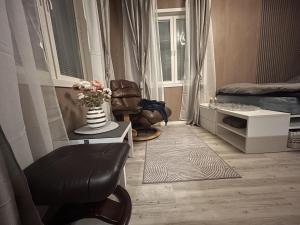 uma sala de estar com uma cadeira e um vaso de flores em Brand New Studio Apartment in Tromso - hotspot em Tromsø