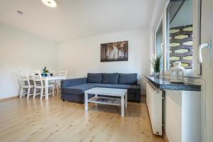 a living room with a blue couch and a table at Ferienwohnung Große in Osterode