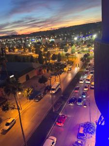 Una ciudad con coches estacionados en una calle por la noche en Appart Hotel Monaco en Tánger