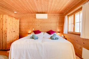 KüblisにあるGemütliches Chalet mit schöner Aussichtの木製の部屋にベッド1台が備わるベッドルーム1室があります。