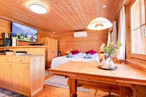 um quarto com uma cama e uma mesa num quarto em Gemütliches Chalet mit schöner Aussicht em Küblis