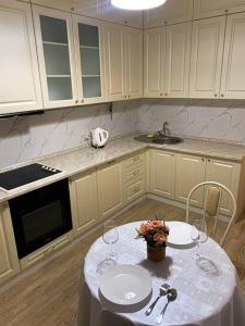 uma cozinha com uma mesa com dois copos de vinho em 1-комнатная квартира посуточно em Taldykolʼ