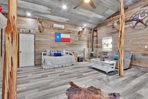 a living room with wooden walls and a couch and a table at Bulverde Cottage at Moonlight Getaway in Bulverde