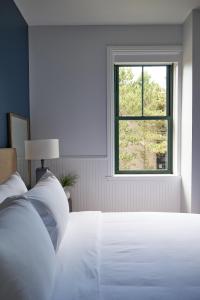 a white bed in a room with a window at The Docent's Collection in Portland