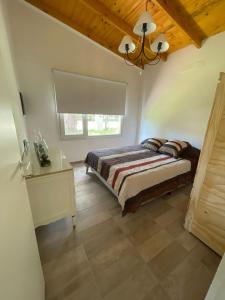 Schlafzimmer mit einem Bett und einem Kronleuchter in der Unterkunft “La Espera” cada de campo in Gardey