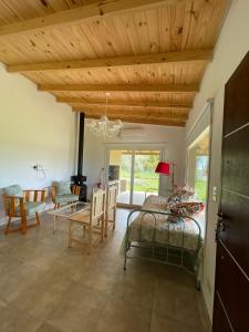 ein Wohnzimmer mit einer Holzdecke sowie einem Tisch und Stühlen in der Unterkunft “La Espera” cada de campo in Gardey