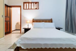 a bedroom with a large white bed and a chair at Casa aconchegante em Floripa RBF142 in Florianópolis