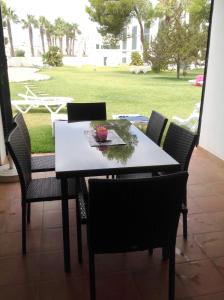 a dining room table with chairs and a view of a yard at 2 bedrooms appartement at Ciutadella de Menorca 200 m away from the beach with shared pool and enclosed garden in Cala en Bosc