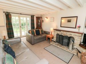 a living room with a couch and a fireplace at Holly Cottage in Whitby