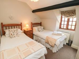 a bedroom with two beds and a window at Holly Cottage in Whitby