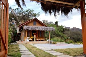 een klein huis met een veranda en een tafel bij Casa Kambana en Vilcabamba in Loja