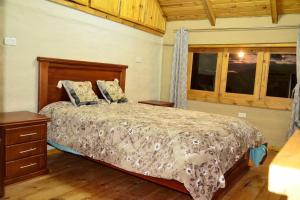 Schlafzimmer mit einem Bett und Holzboden in der Unterkunft Casa Kambana en Vilcabamba in Loja