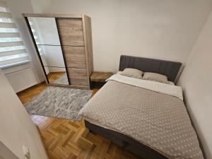 a bedroom with a bed and a large mirror at Apartman Dionis in Užice