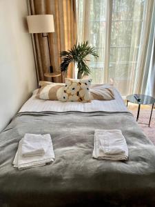 a bed with two towels on it with a window at Garden City Apartment, Helsinki - Vantaa Airport in Vantaa
