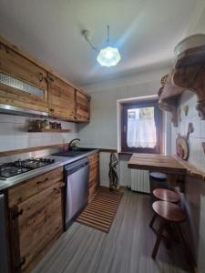 a kitchen with wooden cabinets and a stove top oven at L'Atelier du Temps - Casa Margherita in Courmayeur