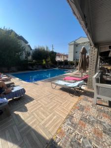 a backyard with a swimming pool and a patio at Imperial Apart in İçmeler
