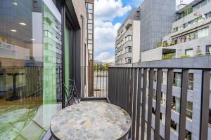 balcone con tavolo e alcuni edifici di L'appart Léon, avec sauna a Liegi