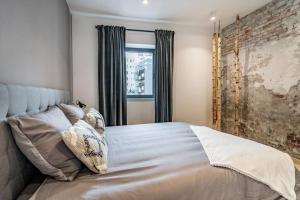 um quarto com uma cama com almofadas e uma janela em L'appart Léon, avec sauna em Liège