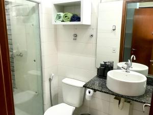 La salle de bains est pourvue de toilettes, d'un lavabo et d'une douche. dans l'établissement Mobiliado e aconchegante, à Belém