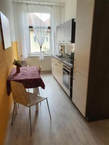 a small kitchen with a table and a window at Halle Saale 402 in Ammendorf