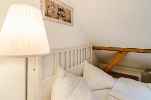 - une chambre avec un lit doté d'une lampe et d'oreillers dans l'établissement Huus an´t Koornfeld Dachgeschoss, à Osteel