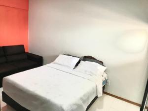 een slaapkamer met een wit bed en een zwarte stoel bij Mobiliado e aconchegante in Belém