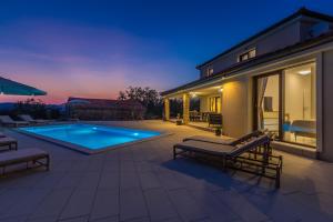 a backyard with a swimming pool and a house at Holiday house LUNA in Bajčići
