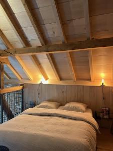 ein großes Bett in einem Zimmer mit Holzdecken in der Unterkunft Hoeve Appartement aan de rand van Maastricht met natuurzwembad in Berg en Terblijt