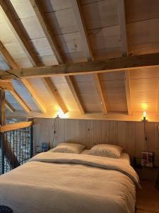 een groot bed in een kamer met houten plafonds bij Hoeve Appartement aan de rand van Maastricht met natuurzwembad in Berg en Terblijt