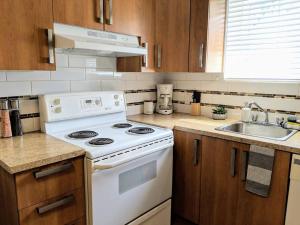 cocina con fogones blancos y fregadero en 2 bedrooms apartment with private parking 5 minutes from Montreal, en Longueuil