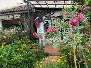 un jardín con flores rosas frente a una casa en Family house - stay on pine hill Dalat en Xuan An