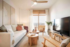 a living room with a white couch and a flat screen tv at Almuñecar Seawiews Deluxe SinEsedesignhomes in Almuñécar