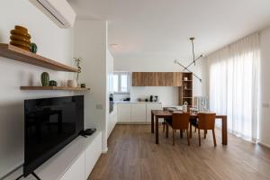 uma cozinha e sala de jantar com uma grande televisão de ecrã plano em La casa di GABRIELLA em Milão