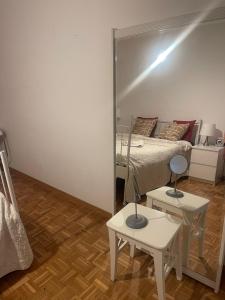 a mirror in a room with a bed and two tables at Chambre Cosy in Lausanne