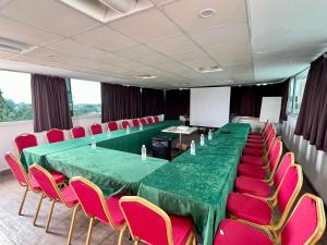 una sala de conferencias con una mesa verde y sillas rojas en Residence ACHENBACH, en Abiyán