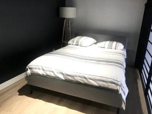 łóżko z białą pościelą i poduszkami w sypialni w obiekcie Très beau loft avec terrasse w mieście Saint-Étienne