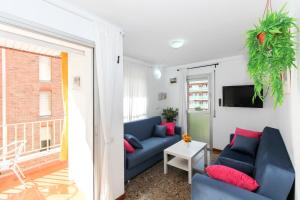 a living room with a blue couch and red pillows at Apartamento Disa in Lloret de Mar