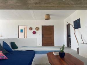 a bedroom with a blue bed and a wooden table at Sitio Lipa - Villa da Mata in São Miguel Arcanjo